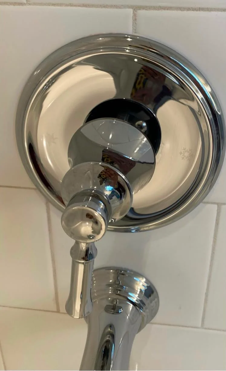 The same shower valve polished back to mirror-bright chrome after treatment