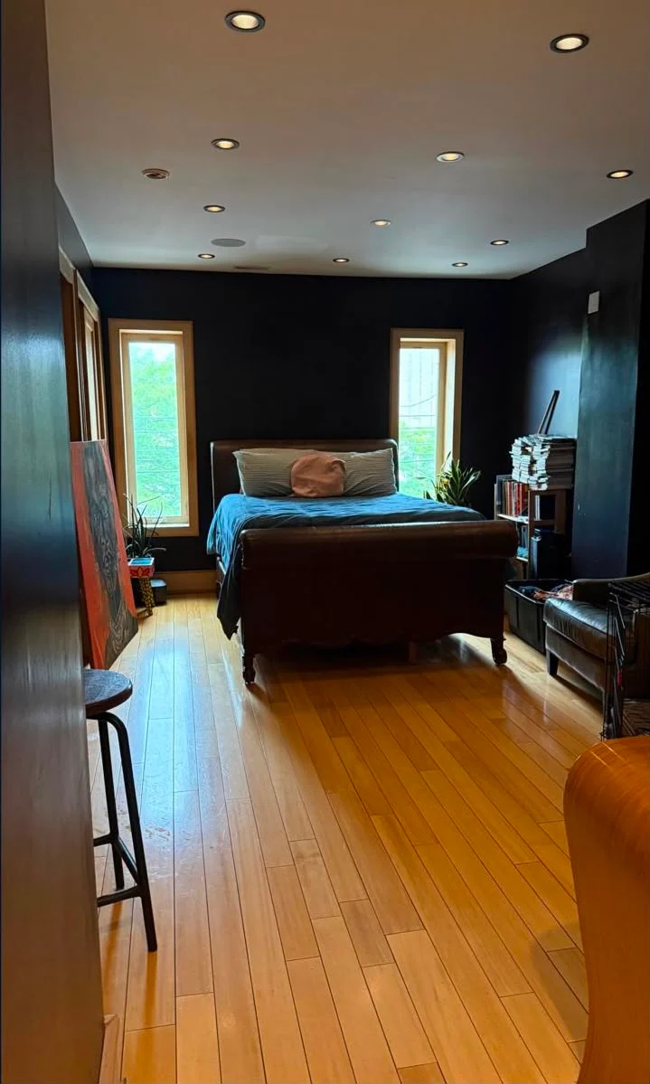 The same master bedroom fully organised with clear polished hardwood floors after cleaning